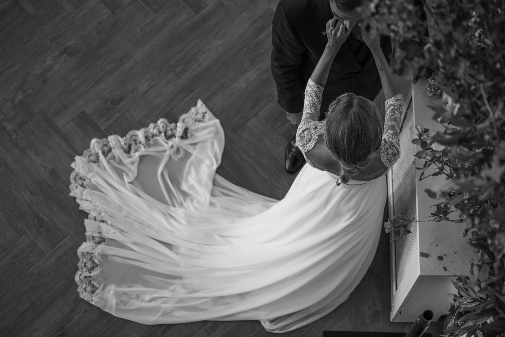 Fotografía de boda en blanco y negro con vestido cola larga hecho a medida